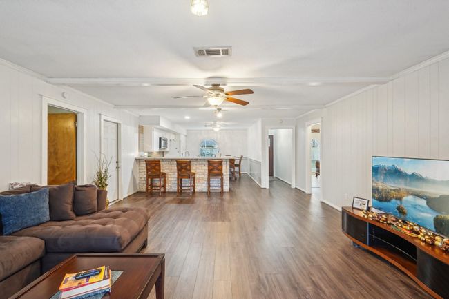 This spacious living area features a cozy fireplace. | Image 9
