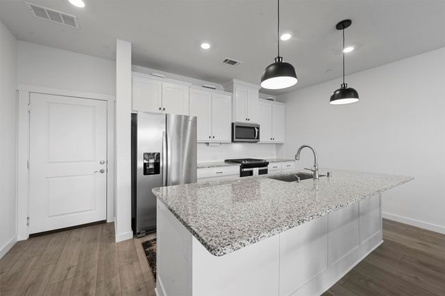 Kitchen featuring appliances with stainless steel finishes, sink, a center island with sink, and white cabinets | Image 6