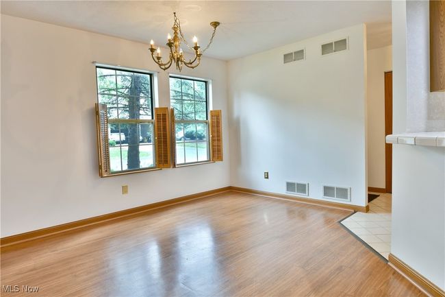 Unfurnished dining area featuring a chandelier and light wood-style floors | Image 7