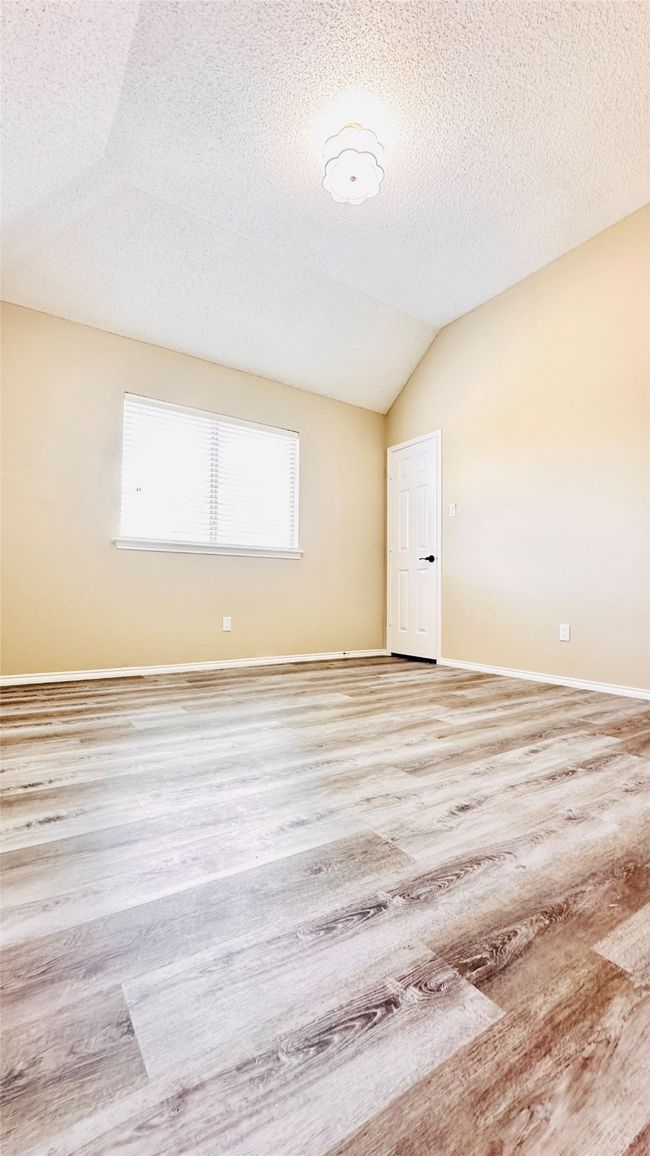 Empty room featuring vaulted ceiling, and a textured ceiling | Image 10