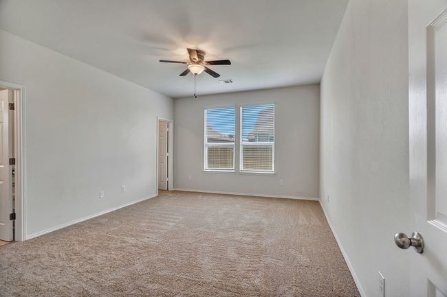 Empty room with a ceiling fan and light carpet | Image 17