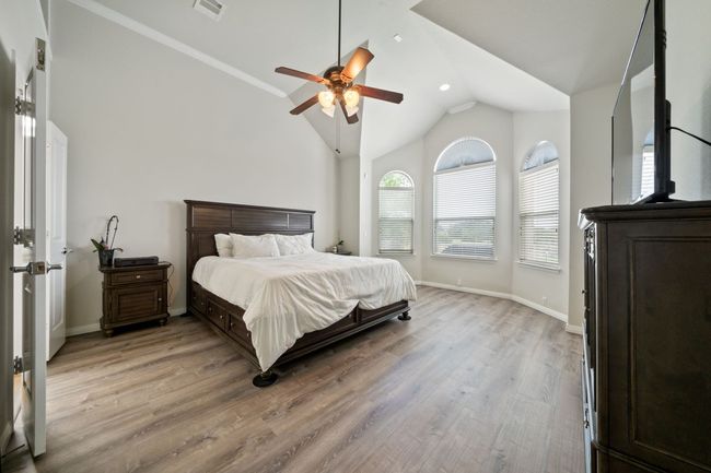 Bedroom featuring light wood-style flooring, lofted ceiling, and a ceiling fan | Image 13
