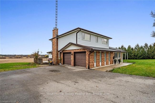 View of front of home featuring covered porch, a garage, and a front lawn | Image 36