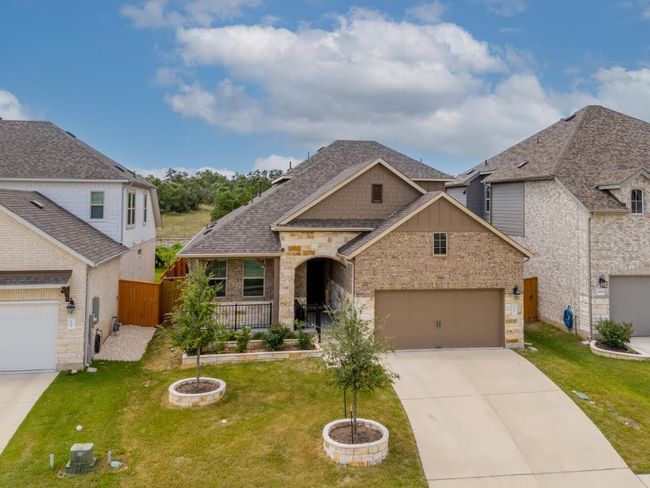 View of front facade with concrete driveway, brick siding, a shingled roof, and an attached garage | Image 4