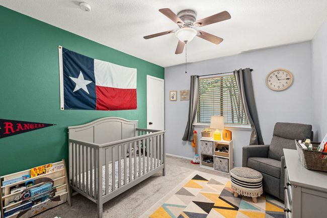 Carpeted bedroom featuring a nursery area and a ceiling fan | Image 15