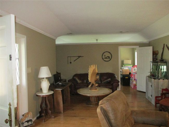 Living room featuring wood-type flooring, lofted ceiling, and crown molding | Image 21