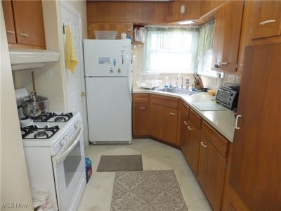 Kitchen featuring white appliances, sink, and extractor fan | Image 3