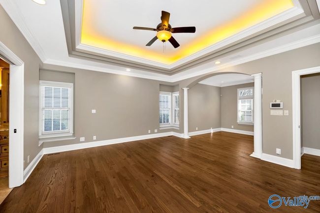 Wood flooring, crown molding, trey ceiling, ceiling fan, recessed lighting, Sitting area | Image 25