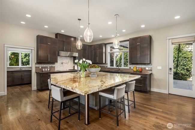 The chef’s kitchen is a culinary showpiece, boasting an oversized island, premium appliances, and an adjoining catering kitchen with a walk-in pantry, making hosting effortless and memorable. | Image 10