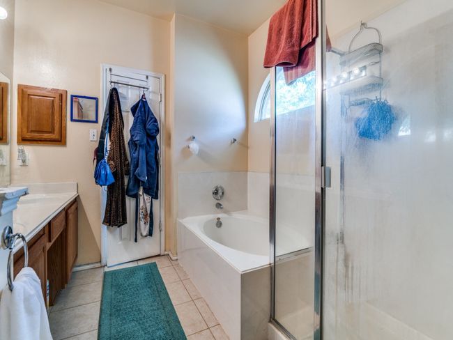 Bathroom featuring a bath, tile patterned flooring, vanity, and a stall shower | Image 21