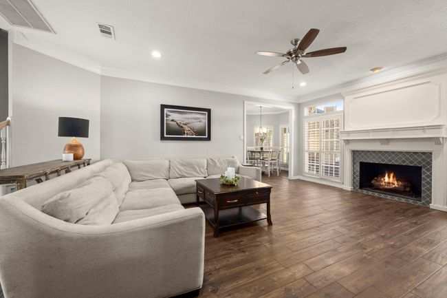 This living space your vibe? Classic style meets modern color palette. Mantel is crisp and gorgeous! And the tile is perfection. This open living room is ready for family movie nights... with just enough privacy in the kitchen to keep the movie night dishes hidden. | Image 10