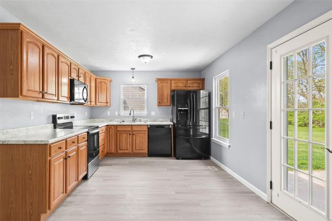 Spare room with visible vents, ceiling fan, wood finished floors, and a healthy amount of sunlight | Image 8