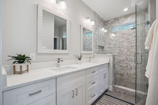Full bath with double vanity, a shower stall, and tile patterned floors | Image 22