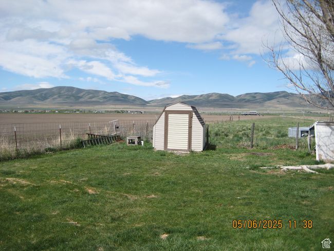 View of yard featuring fence, a storage shed, and a mountain view | Image 8