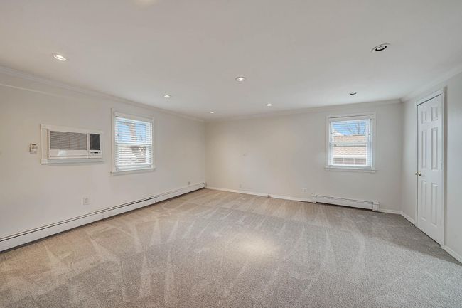 Empty room featuring ornamental molding, light colored carpet, and a baseboard radiator | Image 20