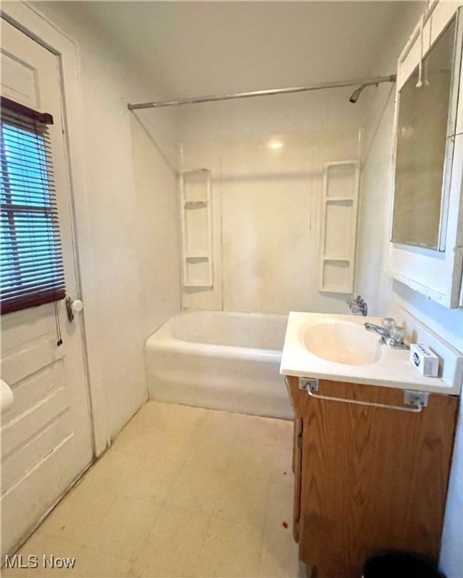 Full bathroom with tile patterned floors, shower / washtub combination, and vanity | Image 16