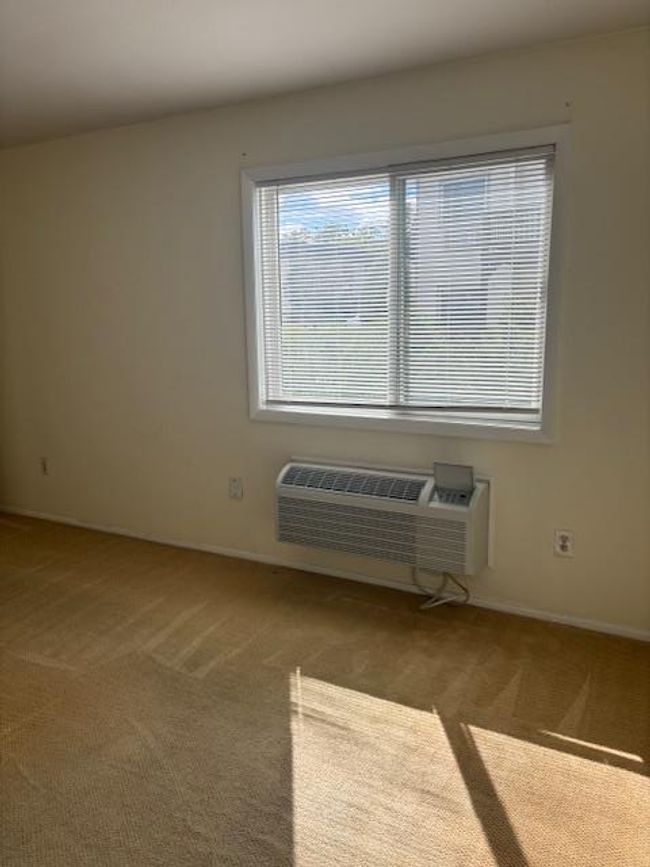 Bedroom with wall mounted ac/heat unit and double window | Image 10