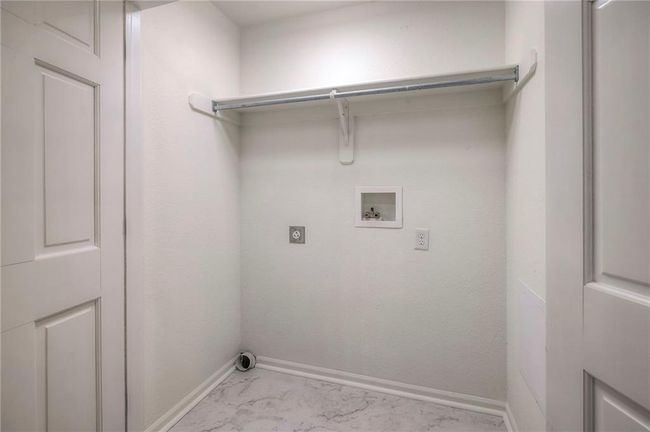 Laundry area featuring electric dryer hookup, hookup for a washing machine, and light marble finish flooring | Image 15