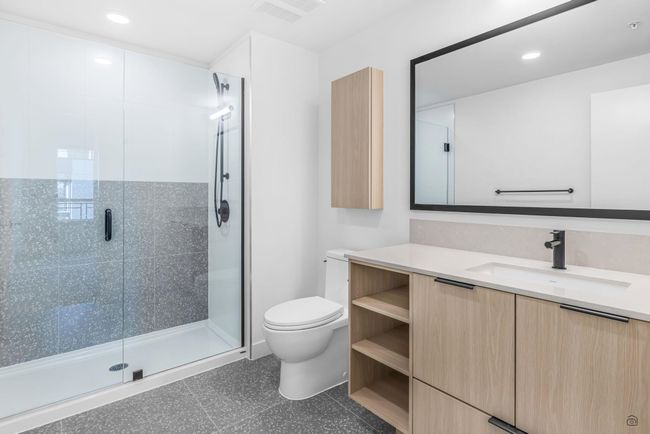 Bathroom with visible vents, a stall shower, toilet, and vanity | Image 13