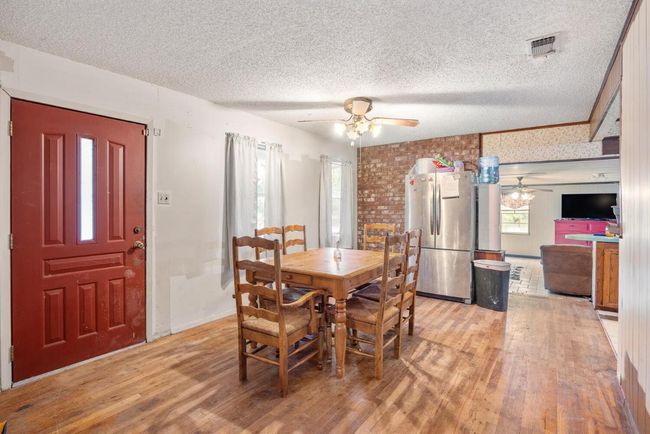Dining space with a textured ceiling, a ceiling fan, visible vents, and light wood-style floors | Image 11