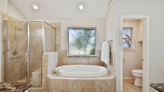 Full bathroom featuring a stall shower, a bath, toilet, tile patterned flooring, and vaulted ceiling | Image 27
