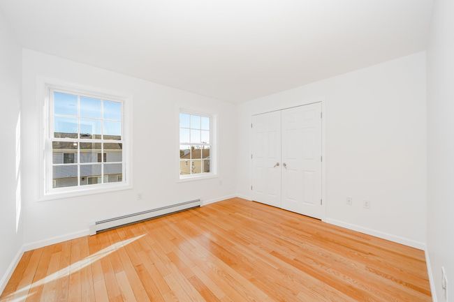 Empty room with baseboards, light wood-style flooring, and baseboard heating | Image 16