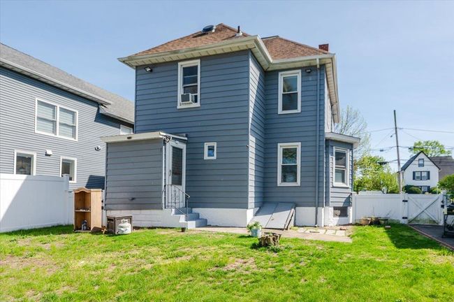 Back of property featuring a yard, a chimney, fence, entry steps, and a gate | Image 21