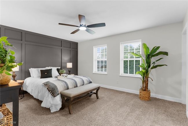 Bedroom with light colored carpet, ceiling fan, and a decorative wall | Image 20