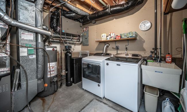 Utility/laundry room with laundry tub, new Maytag washer & dryer (2025), & new Energy Star air exchange system (2025), & self-metering water softener. Lennox furnace (2020) & Lennox central air (2021). | Image 35