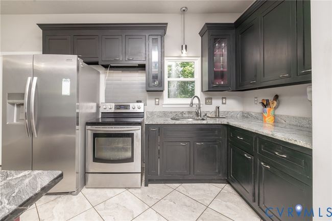 Kitchen featuring appliances with stainless steel finishes, light stone countertops, and glass insert cabinets | Image 37