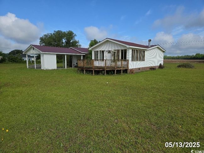 Rear view of property featuring a deck, a yard, and crawl space | Image 12