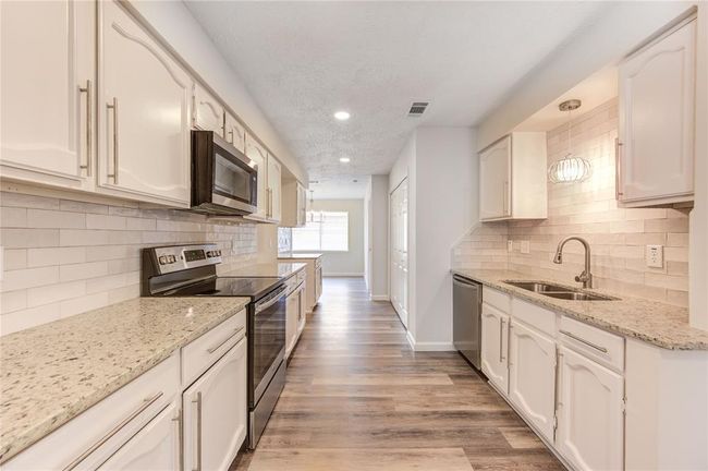 Large kitchen with gorgeous updates! The updates include new granite and backsplash, new sink and faucet, new appliances, new LED recessed lighting and light fixtures and new cabinet handle pulls. | Image 8