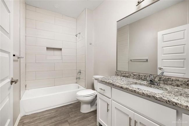 Bathroom with wood finished floors, vanity, and tub / shower combination | Image 11