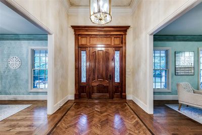 Entryway featuring dark hardwood / wood-style floors, plenty of natural light, a chandelier, and ornamental molding | Image 3