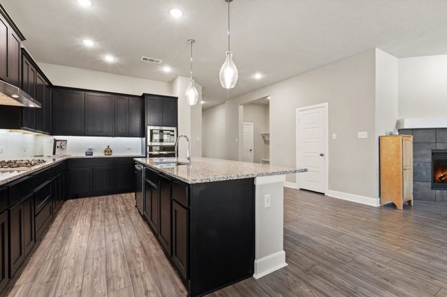 Stainless Steel appliances and granite countertops in this open kitchen with a huge island. | Image 15