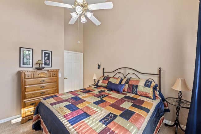 Carpeted bedroom with a towering ceiling, baseboards, and a ceiling fan | Image 34