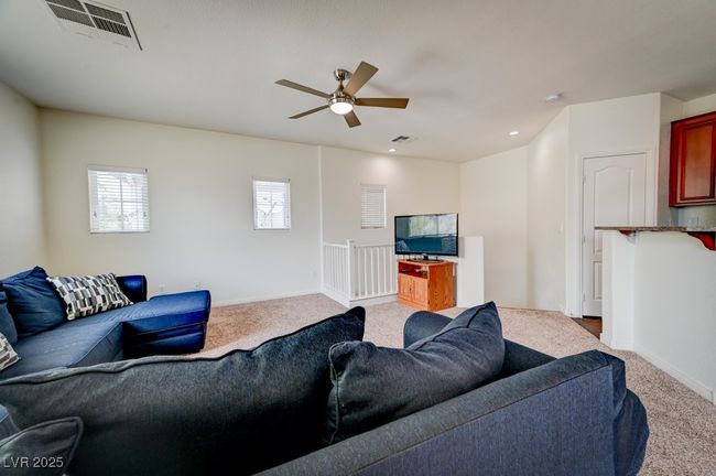 Carpeted living area featuring ceiling fan and baseboards | Image 4