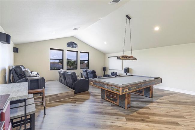 Game room with visible vents, lofted ceiling, wood finished floors, pool table, and baseboards | Image 22
