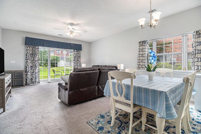 Dining room with a chandelier, carpet floors, and a textured ceiling | Image 5
