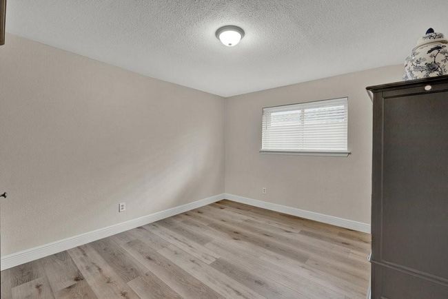 Empty room featuring baseboards, a textured ceiling, and wood finished floors | Image 25