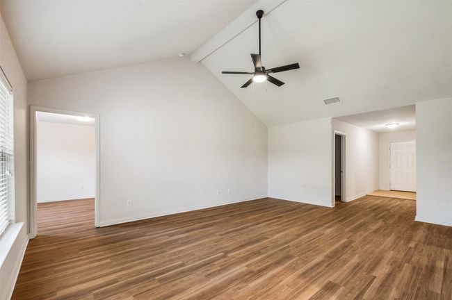 Empty room with ceiling fan, wood finished floors, and baseboards | Image 7
