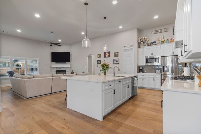 Kitchen featuring a sink, light wood-style flooring, ceiling fan, and stainless steel appliances | Image 7