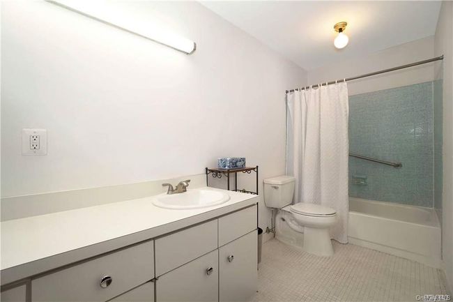 Full bathroom featuring toilet, tile patterned floors, shower / bath combo, and vanity | Image 13