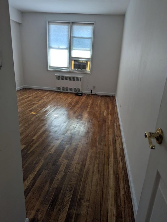 Spare room featuring radiator, dark wood-style flooring, and cooling unit | Image 4