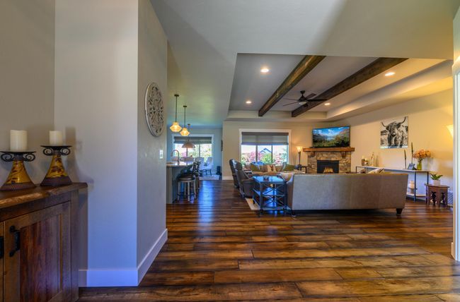 Living area with a ceiling fan, dark wood-type flooring, a fireplace, beam ceiling | Image 6