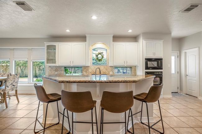 Spacious island kitchen & breakfast bar, 4 burner gas range, whole house water softener & reverse osmosis water filter system at sink. | Image 17