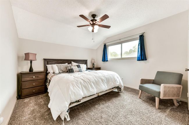 This cozy bedroom features a sloped ceiling and a large window creating a welcoming atmosphere. | Image 32