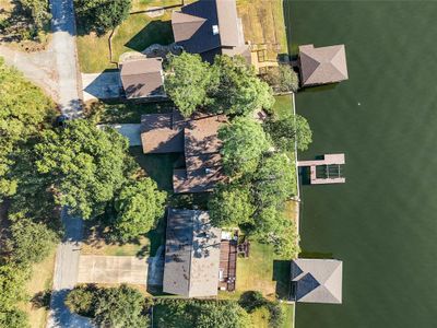 Aerial view of the home shows the footprint of the property with mature trees and boat dock. | Image 3