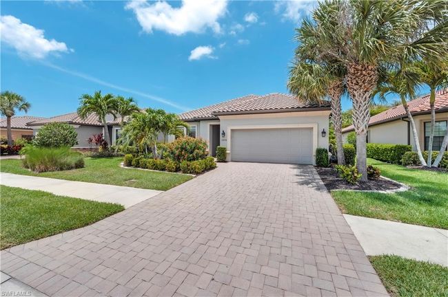 Mediterranean / spanish-style house featuring a front yard, a garage, stucco siding, a tile roof, and decorative driveway | Image 32
