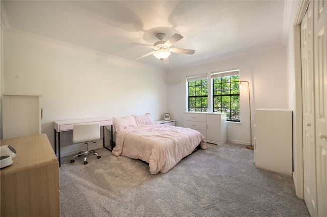 Bedroom with a ceiling fan, carpet, and ornamental molding | Image 11